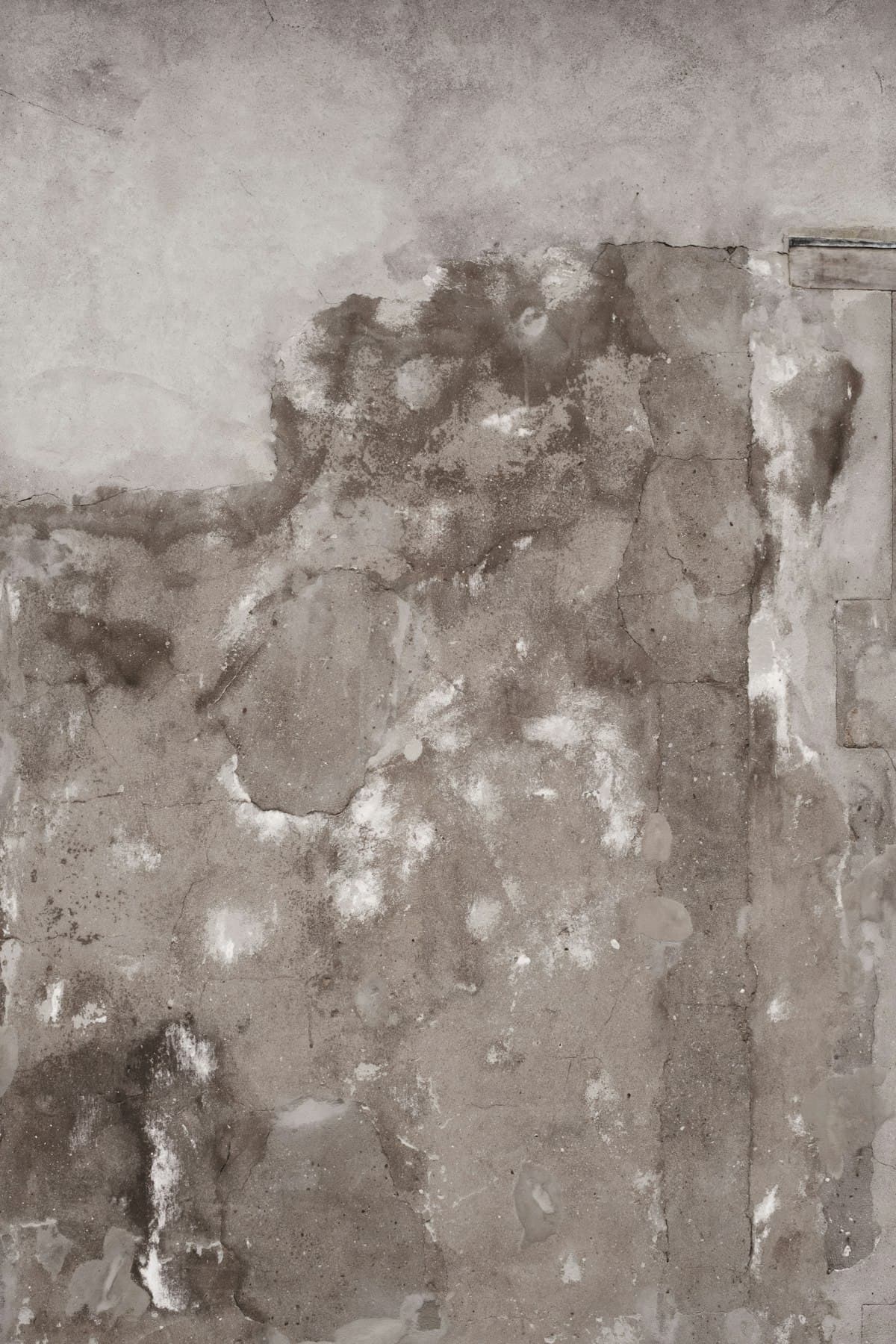Mur intérieur avec taches d'humidité et salpêtre blanc en pied de mur — signe typique de remontées capillaires